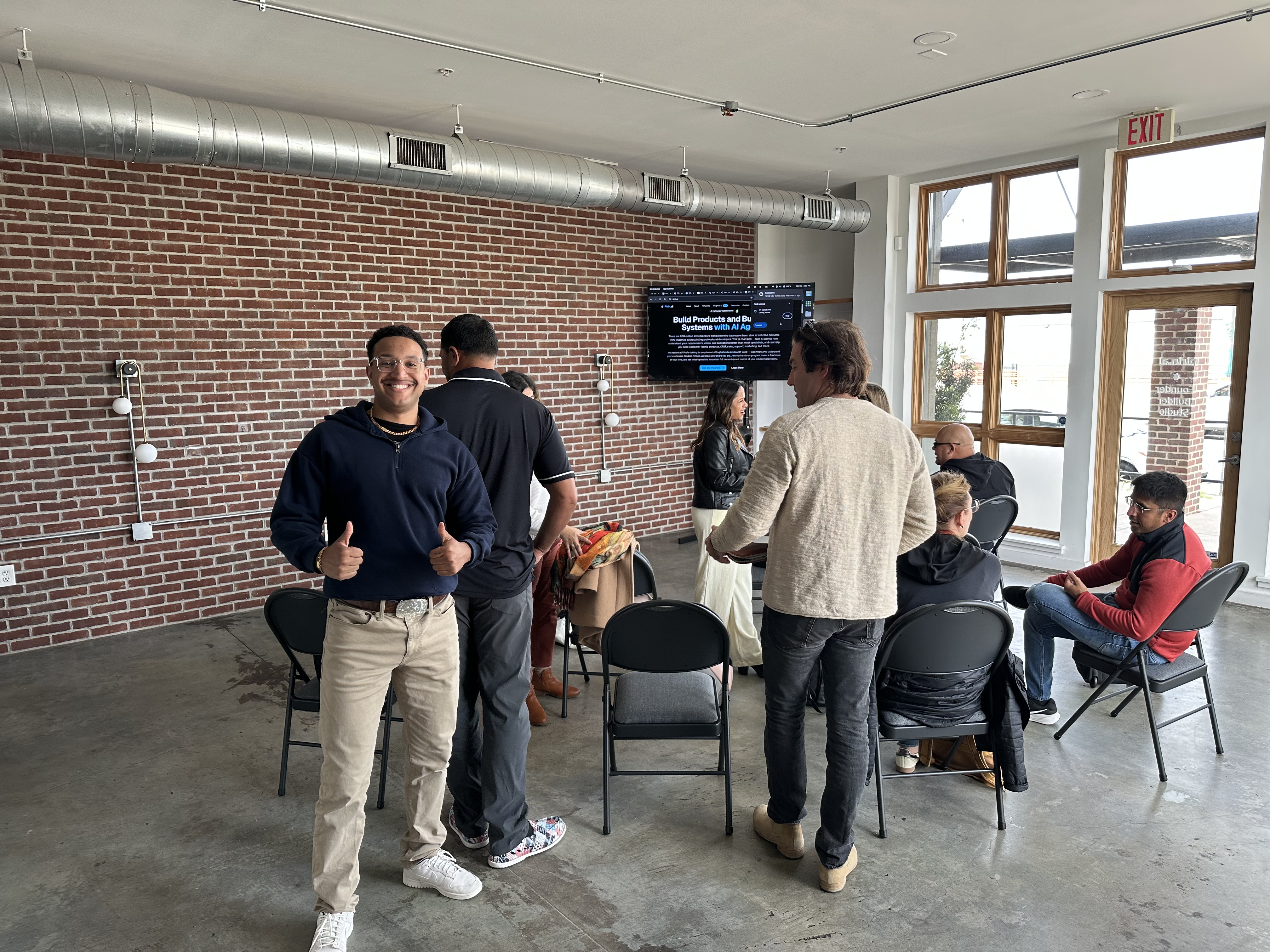 Founders networking after the SXSW Building Teams with Agents meetup, Pirin.ai site visible on the wall screen